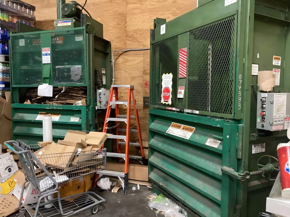 Industrial vertical baler in a metal factory setting